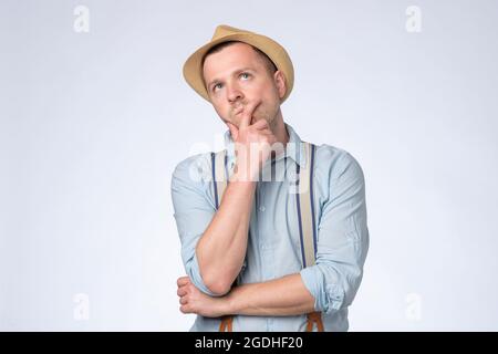 Young thoughtful man looking up generating idea, making plans for future. Stock Photo
