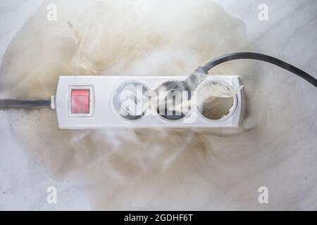 Failure caused by burning of the wire cable and socket outlet plug in the house, blurred photo, concept blurred background, selective focus. Stock Photo