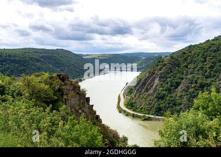 The river Rhine in western Germany flows between the hills covered with forest, visible river bend and rock cliff. Stock Photo