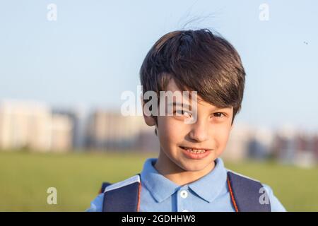 Portrait of happy boy with backpack, school child waiting for school bus, primary school student, on the way to school Stock Photo