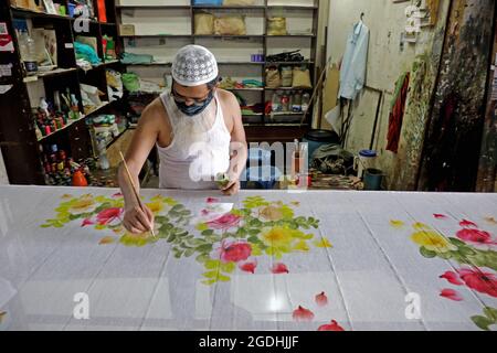 Dhaka, Bangladesh. 13th Aug, 2021. A craftsman manufactures a fabric with hand-painted designs, in a boutique house. Workers of block and boutique industries of Dhaka New Market, have been allowed to reopen following the new health protocols by Covid-19 after 19 days of severe lockdown. (Photo by Eyepix Group/Pacific Press) Credit: Pacific Press Media Production Corp./Alamy Live News Stock Photo