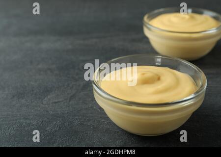 Bowls with cheese sauce on dark background Stock Photo