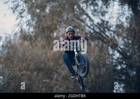 Professional young sportsman cyclist with bmx bike at skatepark Stock Photo