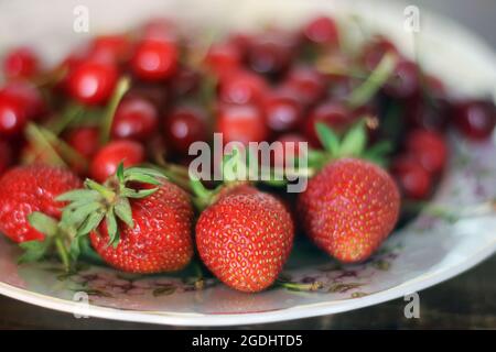 Strawberries and cherries on a plate. Berry harvest Stock Photo