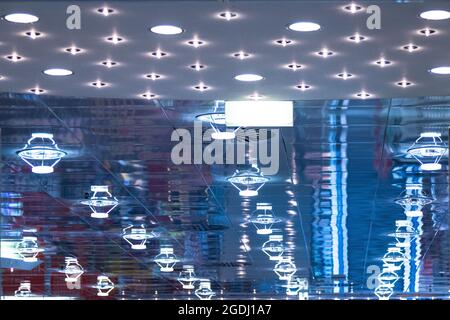 Ceiling lamps are reflected in glass, creating blue light with many structures. Stock Photo