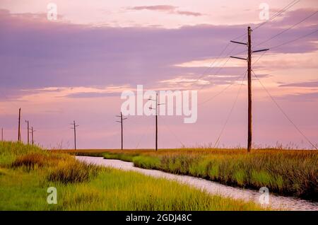 The sun sets over Heron Bay at the Heron Bay Cutoff, Aug. 12, 2021, in Coden, Alabama. Stock Photo