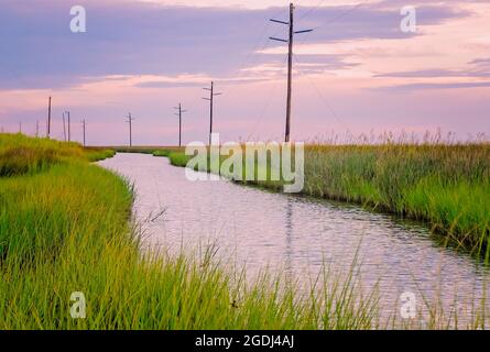 The sun sets over Heron Bay at the Heron Bay Cutoff, Aug. 12, 2021, in Coden, Alabama. Stock Photo