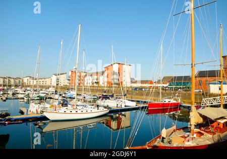 A wide view of Ardrossan Harbour and Clyde Marina with apartments in the background Stock Photo