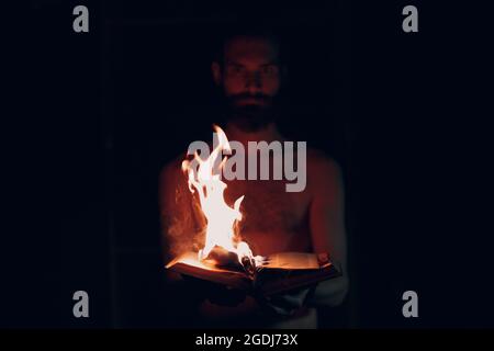 Man hold burning book in his hands Stock Photo
