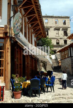 BOSNIA AND HERZEGOVINA MAY 2006 A PAVEMENT CAFE IN THE SHADOW OF A BOMBED OUT BUILDING IN MOSTAR PIC MIKE WALKER, Stock Photo