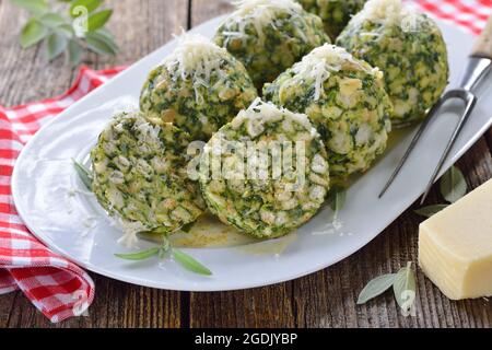 South Tyrolean spinach dumplings made of white bread and fresh spinach leaves, served with melted sage butter and grated parmesan cheese Stock Photo