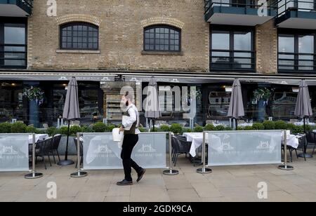 London, UK. 13th Aug, 2021. A waiter is seen at a restaurant in London, UK, on Aug. 13, 2021. Another 32,700 people in UK have tested positive for COVID-19, bringing the total number of coronavirus cases in the country to 6,211,868, according to official figures released Friday. Credit: Han Yan/Xinhua/Alamy Live News Stock Photo
