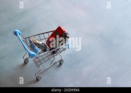 Buying car, car sales and car ownership concept. Cars in shopping trolley Stock Photo