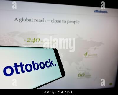 Smartphone with logo of German prosthetics company Ottobock SE Co. KGaA on screen in front of website. Focus on center-right of phone display. Stock Photo