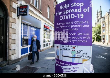 Edninburgh, UK. 15th July, 2021. A man wearing a face mask walks past 'Help stop the spread of COVID-19' advert displayed in Edinburgh, Scotland. (Photo by Dinendra Haria/SOPA Images/Sipa USA) Credit: Sipa USA/Alamy Live News Stock Photo