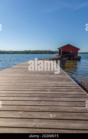 Wooden jetty, boathouse and ocean in Åland Islands, Finland, on a sunny day in the summer. Stock Photo