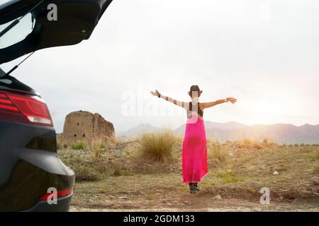 rear view young asian woman car traveler in red dress enjoying the morning sunlight on the road Stock Photo