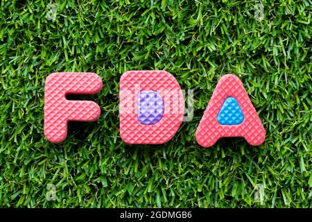 Color alphabet letter in word FDA (abbreviation of food and drug administration) on artificial green grass background Stock Photo