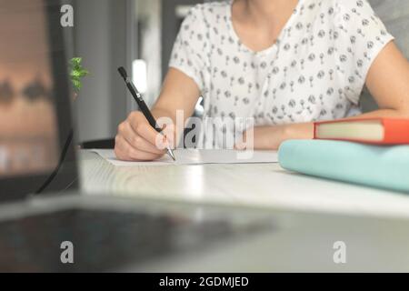 Woman writing and searching internet on laptop computer. E-learning and online study concept. Management and education background Stock Photo