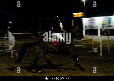 Gaza City, Gaza Strip, Palestine. 13th Aug, 2012. Gaza, Palestine. 13 August 2021. Male and female riders compete in the show-jumping championship at the Al Jawad Equestrian Club in Gaza City. The equestrian event has been organised by the Palestinian Equestrian Federation (Credit Image: © Ahmad Hasaballah/IMAGESLIVE via ZUMA Press Wire) Stock Photo