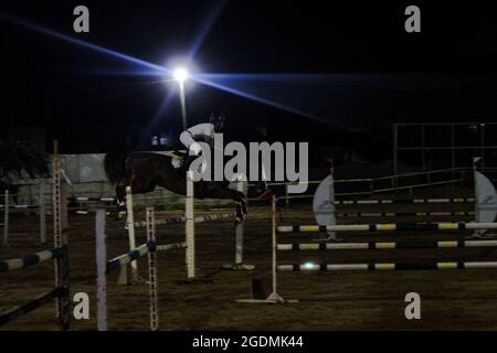 Gaza City, Gaza Strip, Palestine. 13th Aug, 2012. Gaza, Palestine. 13 August 2021. Male and female riders compete in the show-jumping championship at the Al Jawad Equestrian Club in Gaza City. The equestrian event has been organised by the Palestinian Equestrian Federation (Credit Image: © Ahmad Hasaballah/IMAGESLIVE via ZUMA Press Wire) Stock Photo