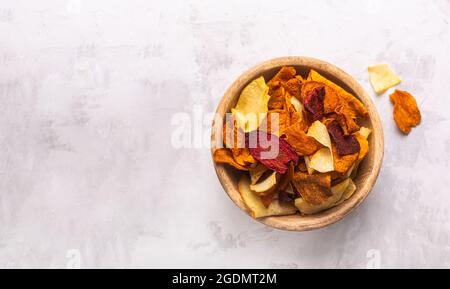 Vegetable chips from potatoes, carrots and beets in a bowl top view. Copy space Stock Photo