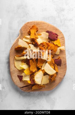 Vegetable chips close-up of potatoes, beets, carrots on a wooden board top view Stock Photo