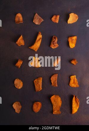 Rows of dried potato, beet and carrot vegetable chips on black background Stock Photo