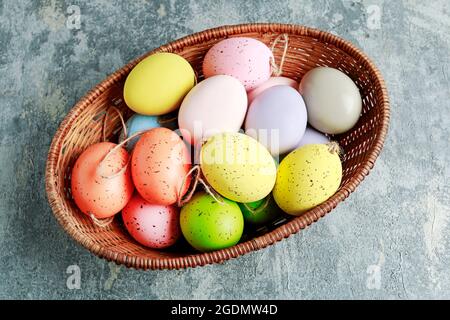 Basket of colorful Easter eggs on grey, stone background. festive decor Stock Photo