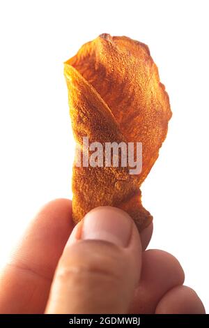 Male hand holds vegetable veggie chips made from potatoes, carrots or beets Stock Photo