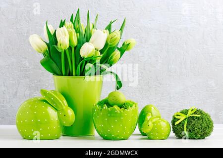 All green: tulips, Easter eggs and bunnies. Seasonal postcard motif. Stock Photo