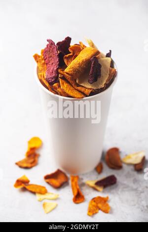 Vegetable organic potato, beet and carrot chips in a white snack glass Stock Photo