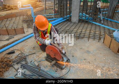 worker cut steel with cutting machine circular disc cuts off part of iron until sparks occur while cutting steel. Stock Photo