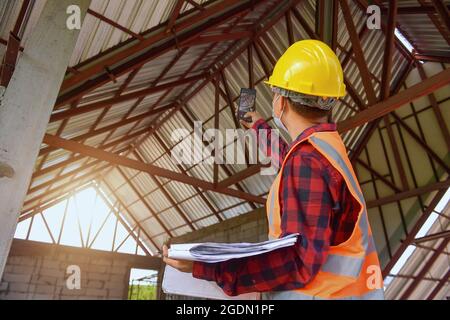 Asian man civil engineer architect wearing safety helmet meeting at contruction site.selective focus Stock Photo