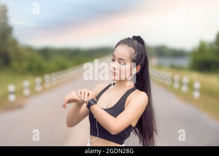 Female runner using smart watch,Young Woman Checking Heart Rate On Smart Watch