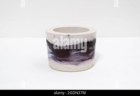 Colorful, purple, handmade cactus pot on a white background with fine holes in the texture Stock Photo