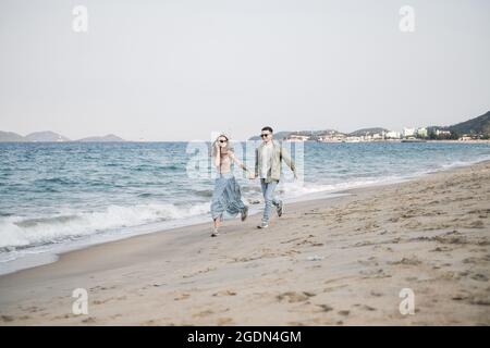 Happy lovers on romantic trip have fun on summer vacation. Concept romance and relaxation. Walking, running, holding hands. High quality photo Stock Photo