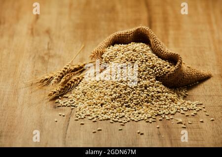 Wheat nuts bag on a wooden table. Wheat nuts in cup. Stock Photo