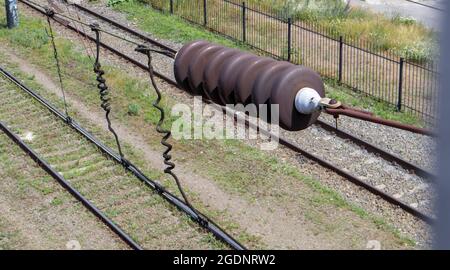 A railroad overhead power line component along a track with a rail electrification system that supplies power to an electric train. Overhead line wire Stock Photo