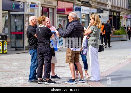 Dundee, Tayside, Scotland, UK. 14th Aug, 2021. UK Weather: A warm breezy day with plenty sunshine across North East Scotland with temperatures reaching 20°C. A group of seniors meet up together to enjoy chatting amongst each other whilst enjoying the warm weather in Dundee city centre. Credit: Dundee Photographics/Alamy Live News Stock Photo