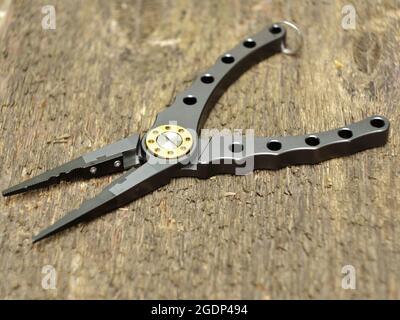 modern fishing pliers on wooden background close-up Stock Photo