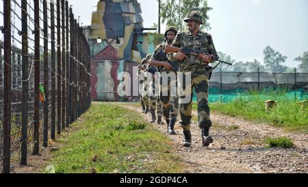 Border Security Force (BSF) personnel patrolling along the barbed wire fence at India-Pakistan border during Independence Day celebrations at RS Pura Sector in Jammu Kashmir on August 14, 2021. (Photo by Bikas Bhagat/INA Photo Agency/Sipa USA) Credit: Sipa USA/Alamy Live News Stock Photo