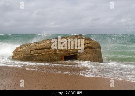 Waves splash against a German bunker from the second world war, fallen from te dunes in the sea in the Tannis Bugt in Denmark Stock Photo