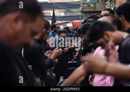 Srinagar, India. 14th Aug, 2021. Kashmiri Shia Muslims beat their chests as they mourn during a muharram procession in Srinagar. Muharram is the first month of Islam. It is one of the holiest months in the Islamic calendar. Shia Muslims commemorate Muharram as a month of mourning in remembrance of the Martyrdom Islamic Prophet Muhammad's grandson Imam Hussain, who was killed on Ashura (10th day of Muharram) in the battle of Karbala in 680 A.D. Credit: SOPA Images Limited/Alamy Live News Stock Photo