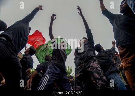 Srinagar, India. 14th Aug, 2021. Kashmiri Shia Muslims beat their chests as they mourn during a muharram procession in Srinagar. Muharram is the first month of Islam. It is one of the holiest months in the Islamic calendar. Shia Muslims commemorate Muharram as a month of mourning in remembrance of the Martyrdom Islamic Prophet Muhammad's grandson Imam Hussain, who was killed on Ashura (10th day of Muharram) in the battle of Karbala in 680 A.D. Credit: SOPA Images Limited/Alamy Live News Stock Photo