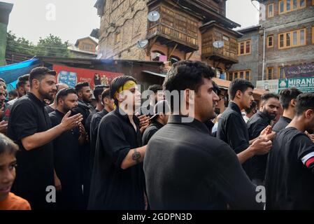 Srinagar, India. 14th Aug, 2021. Kashmiri Shia Muslims beat their chests as they mourn during a muharram procession in Srinagar. Muharram is the first month of Islam. It is one of the holiest months in the Islamic calendar. Shia Muslims commemorate Muharram as a month of mourning in remembrance of the Martyrdom Islamic Prophet Muhammad's grandson Imam Hussain, who was killed on Ashura (10th day of Muharram) in the battle of Karbala in 680 A.D. Credit: SOPA Images Limited/Alamy Live News Stock Photo