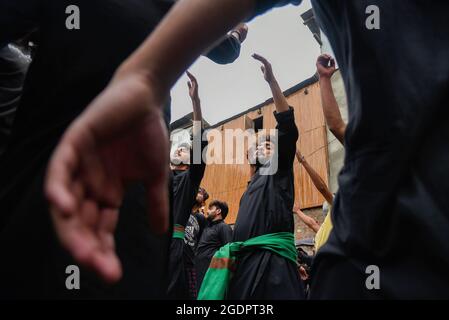 Srinagar, India. 14th Aug, 2021. Kashmiri Shia Muslims beat their chests as they mourn during a muharram procession in Srinagar. Muharram is the first month of Islam. It is one of the holiest months in the Islamic calendar. Shia Muslims commemorate Muharram as a month of mourning in remembrance of the Martyrdom Islamic Prophet Muhammad's grandson Imam Hussain, who was killed on Ashura (10th day of Muharram) in the battle of Karbala in 680 A.D. (Photo by Idrees Abbas/SOPA Images/Sipa USA) Credit: Sipa USA/Alamy Live News Stock Photo