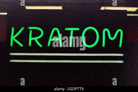 Kratom or Mitragyna speciosa Neon Sign in Rainy Window of Smoke Shop Stock Photo