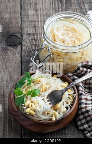 Marinated  sprouted mung beans in glass jar on wooden table