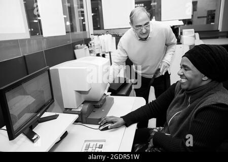JOHANNESBURG, SOUTH AFRICA - Jan 06, 2021: Two males in an interior of a photo printing lab in Johannesburg, South Africa Stock Photo